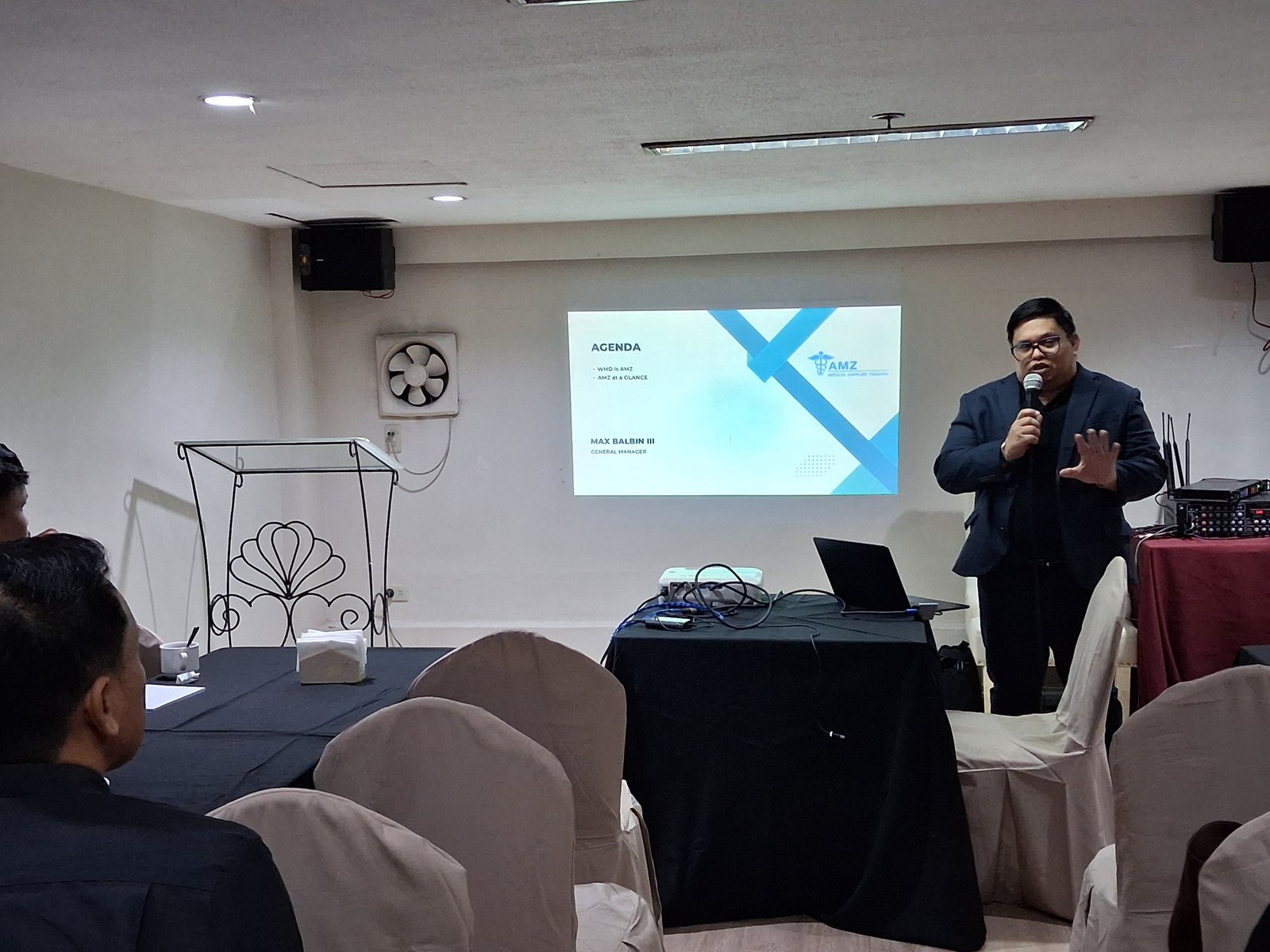 General Manager Max Balbin III presenting the orientation agenda slide, "Who is AMZ" and "AMZ at a Glance."