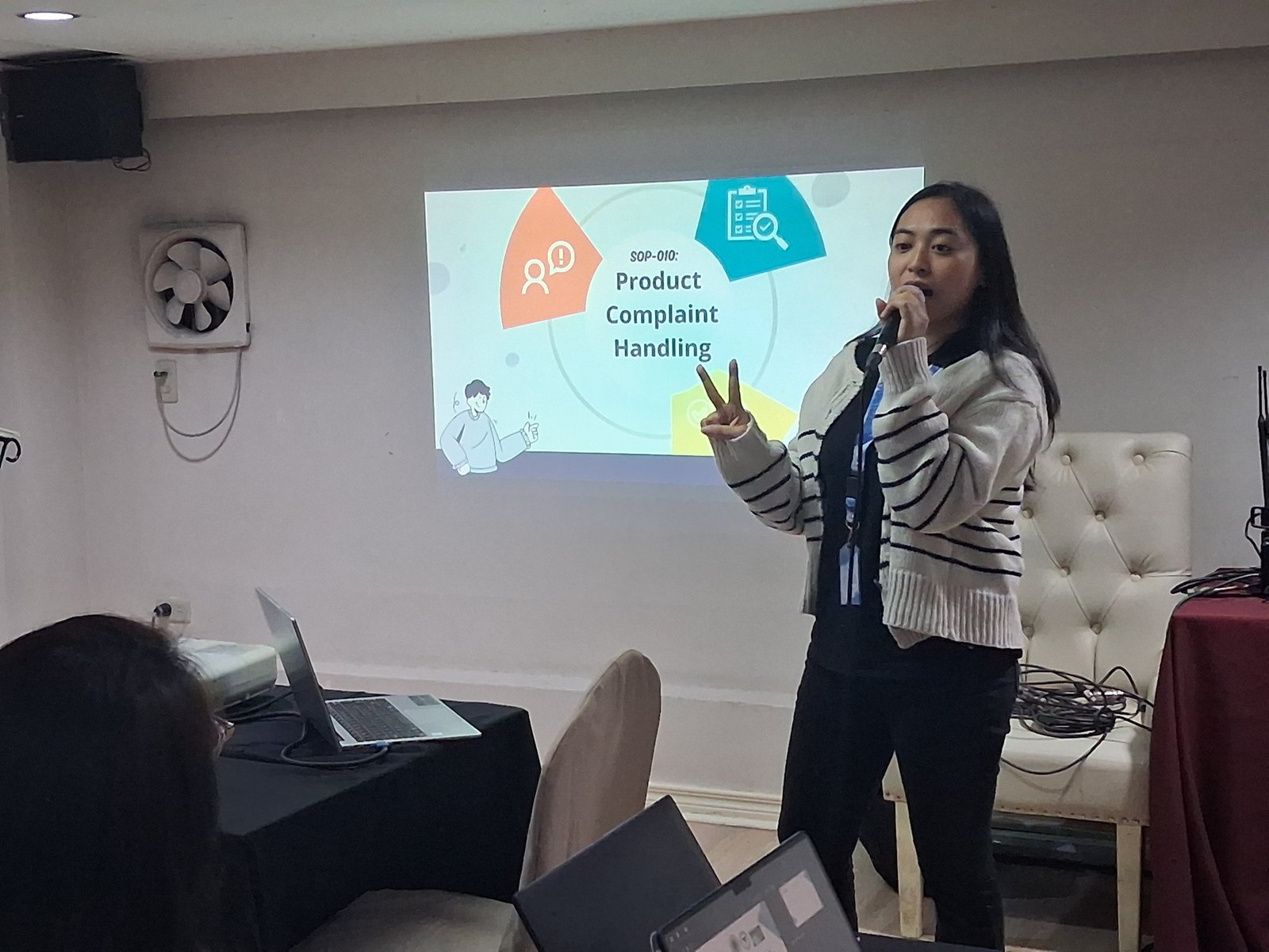 A presenter discussing SOP-010, Product Complaint Handling, during the product orientation.