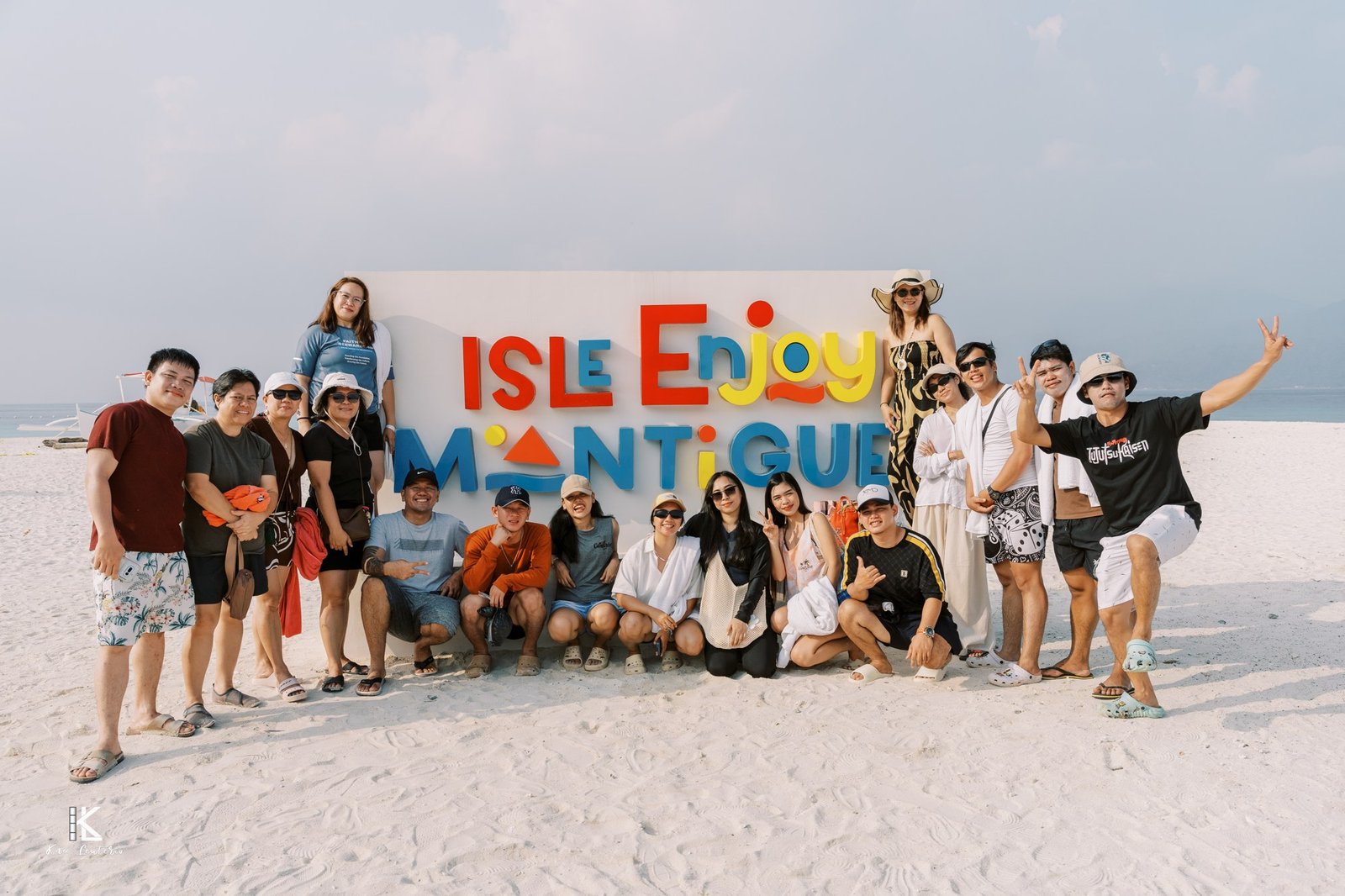 The AMZ team posing in front of the Isle Enjoy Mantigue sign on the white sand beach
